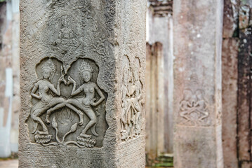 Sculpture of Apsara dancing on a sandstone column in the pagoda of Bayon Angkor Thom Temple, Siem...