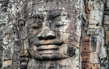 A large figure carved face on sandstone in the pagoda of Bayon Angkor Thom Temple, Siem Reap,...