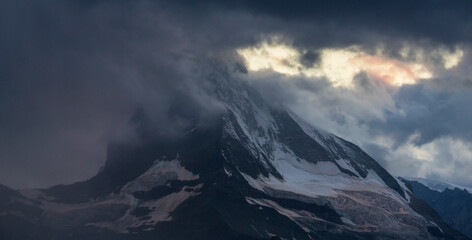 Beautiful evening light and storm cloudscape in the Swiss Alps