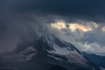 Naklejka na ściany i meble Beautiful evening light and storm cloudscape in the Swiss Alps