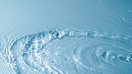 de-focused. Closeup of light blue transparent clear calm water surface texture with splashes and...