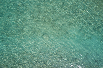 Fototapeta premium clear water top. Turquoise blurred water top view. Stones at the bottom of the water aerial view.