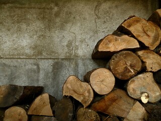 Pila de leña frente a una pared de hormigón. Imagen de una leñera en temporada de invierno.