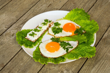 Healthy breakfast - fried eggs, bread with cheese and fresh parsley on a white plate