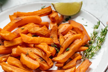 Homemade Baked orange sweet potato fries with lime and herbs, Food recipe background. Close up, top view