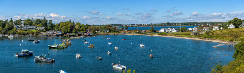 Fototapeta na wymiar Mackerel Cove - A panoramic overview of lobster boats resting in Mackerel Cove at tip of Bailey Island on a sunny Autumn morning. Bailey Island, Harpswell, Maine, USA. 
