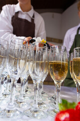 A banquet table with wine glasses and plates with strawberries.