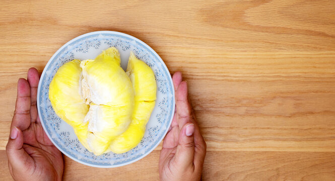 The hands show durian on table wood