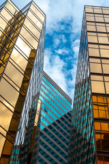 Golden skyscrapper building with blue sky in Hong Kong. Windows glass of modern office architecture design. Architecture exterior for cityscape background. - obrazy, fototapety, plakaty