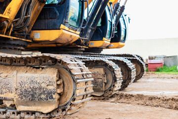 Two powerful excavators work at the same time on a construction site, sunny blue sky in the background. Construction equipment for earthworks.