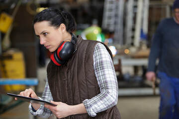 female worker in a factory using a digital tablet