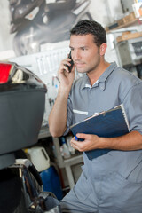 mechanic with folder and cellphone