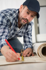 man measuring roll of construction material