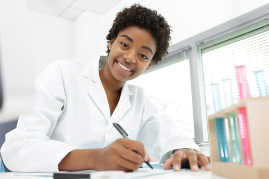 happy female worker taking notes in the lab