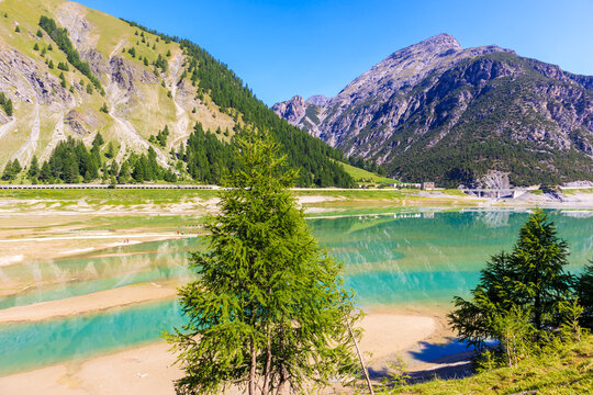 Beautiful lake in Livigno village on sunny summer day, Alps Mountains, Italy
