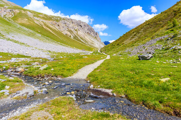 Hiking and mtb bike trial in beautiful Alpisella valley on sunny summer day, Alps Mountains, Italy