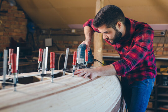 Carpenter assembling new wooden canoe of their own design
