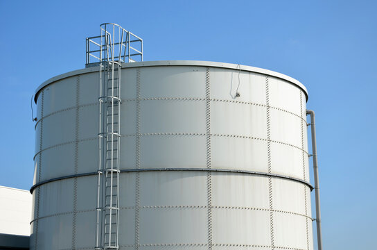 the fire ladder leading to the roof of the hall. cylindrical water tank used to extinguish fires in industrial halls. operations with an increased risk of fire have their tanks for sprinkler presses
