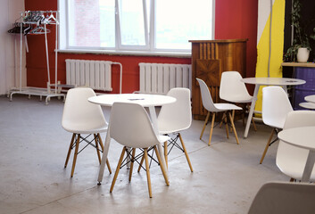 empty coffee shop with white round tables in the office. Dining area in a coworking space