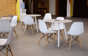 empty coffee shop with white round tables in the office. Dining area in a coworking space