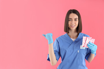 Concept of profession, young female doctor on pink background