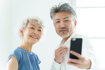 スマートフォンで自撮りをするミドル夫婦