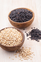 White sesame and black sesame seed on wooden bowl.