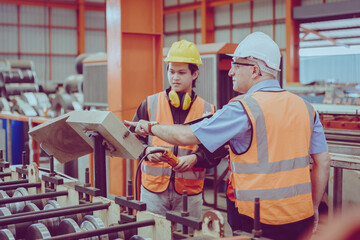 Fototapeta na wymiar Senior Engineer Training Heavy Industry Worker workman service team working in metal factory.