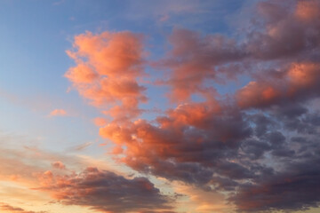 Purple, pink and orange tints clouds in the blue sky at sunset. Big fluffy cumulus cloud. Scenic wallpaper. Nature background. Colorful space. Evening cloudscape. Peace concept. Heaven paradise. Pure