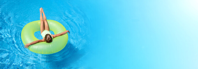 Girl swim in pool with big green rubber ring. Extra wide banner. Copy space for text. Summer...