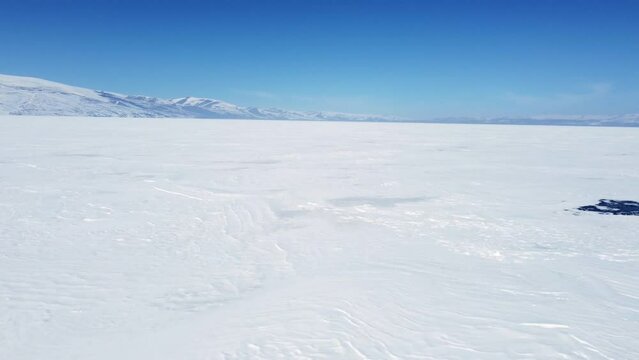 Footage of Flying above the frozen lake Cildir  with a drone at Kars Turkey in winter.