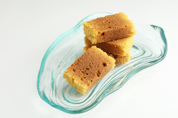 An Indian sweet originated from Mysore made from Ghee called mysore pak served on a glass plate on a white background