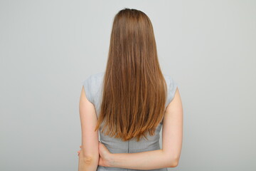 Obraz premium Woman in business dress standing back, female portrait with long hair. Back view. Rear view.