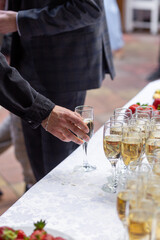 A banquet table with wine glasses and plates with strawberries.