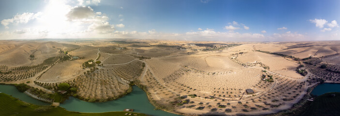 360 degrees panoramic view from the sky to Negev Desert with a small lake at morning