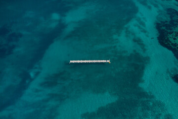 un ponton au milieu de l'eau dans une baie turquoise en Corse