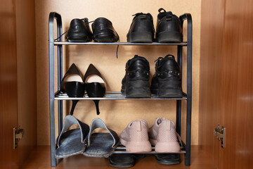 A shelf with shoes in the closet, sneakers, sneakers and shoes are on the shelf in the hallway,...