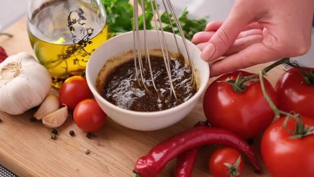 Making chicken marinade for Caesar salad - mixing salt, spices and olive oil in ceramic bowl