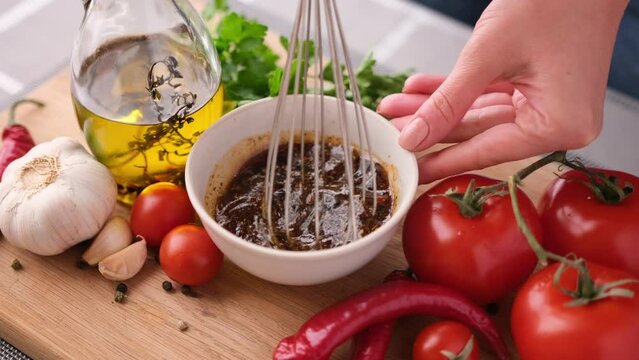 Making chicken marinade for Caesar salad - mixing salt, spices and olive oil in ceramic bowl