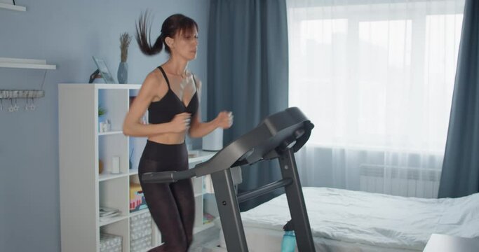 Young women do workout at home running exercising on Treadmill. Burn calories concept