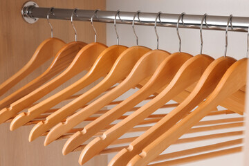 Set of clothes hangers on wardrobe rail, closeup - obrazy, fototapety, plakaty