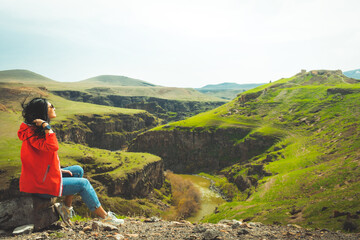 Fototapeta na wymiar Female tourist enjoy sunny windy day in Ani archeological site watch valley. Armenia Turkey border line