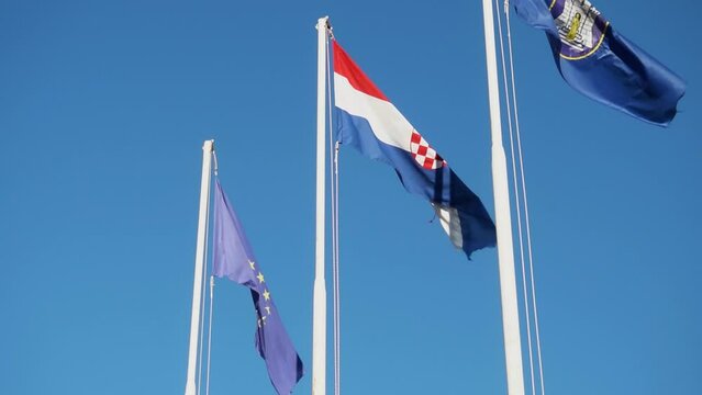 National Flags Of European Union, Croatia And A Local Flag Highly Erected During The Day. Low Angle Shot