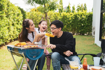 Asian family having a barbecue party at home. Cooking grilled bbq for dinner in backyard. Lifestyle on holiday.