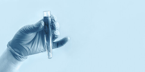 Hand of scientist in blue gloves with test tube on blue background. Medical laboratory testing, analysis and research. Chemistry, science, biology experiment technology, pharmacy. Banner