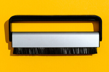 top view einer Schallplatten Bürste auf gelben Hintergrund