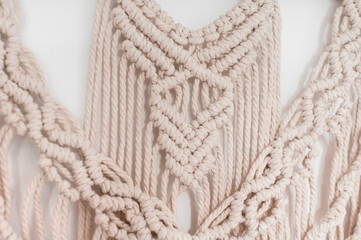 macrame handmade from beige natural threads on a white background