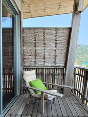 Empty cozy wooden chair standing on wood porch of country house.