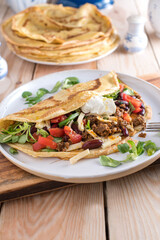 Ground beef pancake or crepe with  vegetables, beans and sour cream