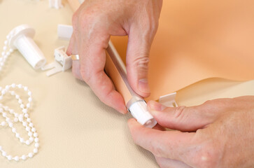 Male hands are assembling roller blinds, close-up. Assembly of roller blinds